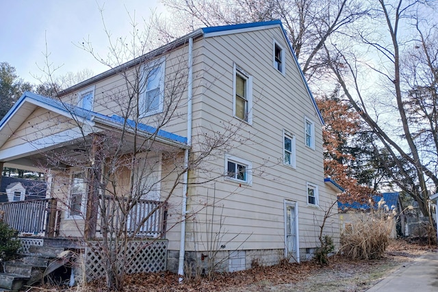 view of side of property with crawl space and covered porch