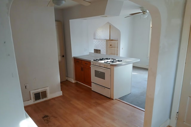 kitchen with visible vents, arched walkways, white range with gas cooktop, and a ceiling fan