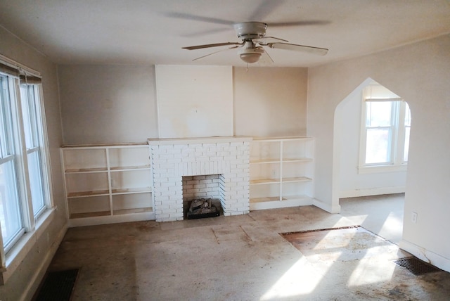 unfurnished living room with a fireplace, visible vents, and ceiling fan