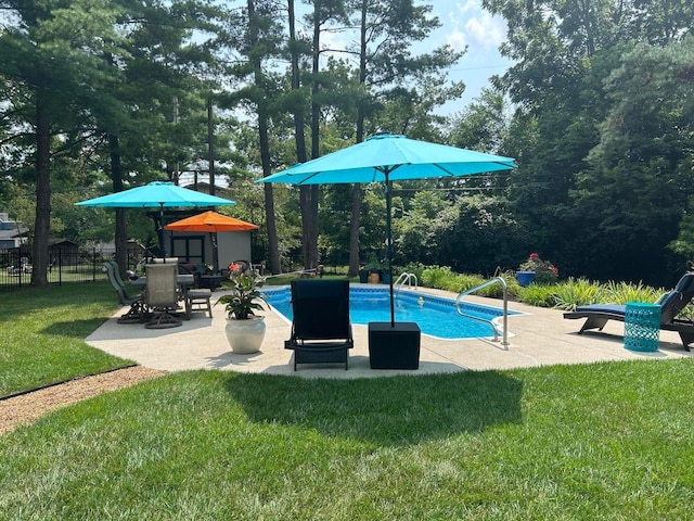 pool with a patio area, a yard, and fence