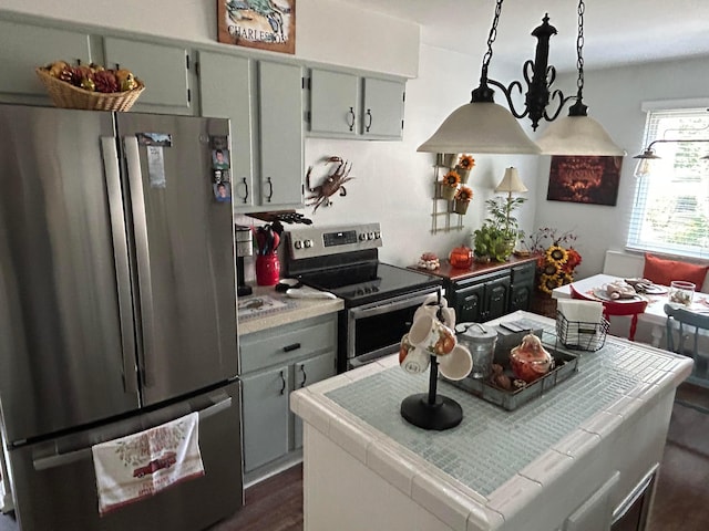 kitchen featuring dark wood finished floors, tile countertops, a kitchen island, and stainless steel appliances