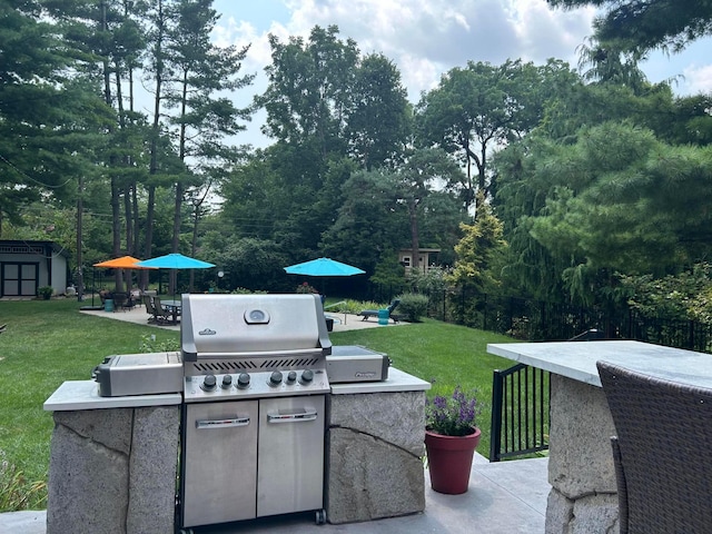 view of patio featuring area for grilling, an outdoor structure, a storage unit, fence private yard, and outdoor dry bar