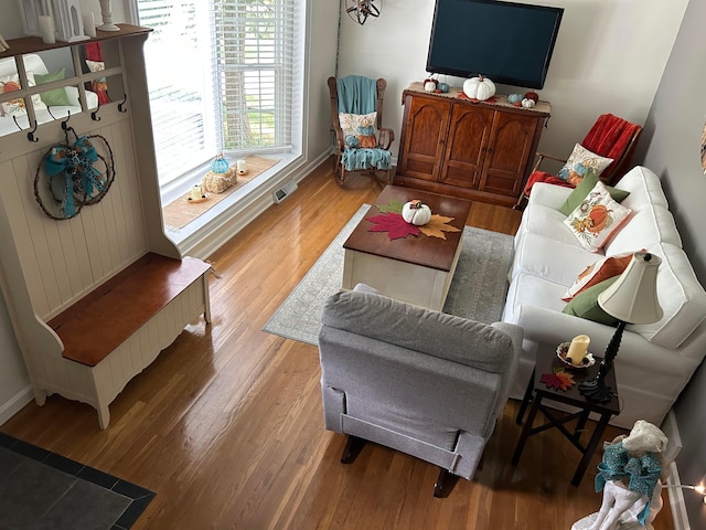 living area with visible vents, light wood-type flooring, and baseboards