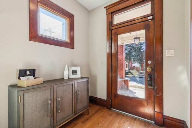 foyer entrance with baseboards and light wood finished floors