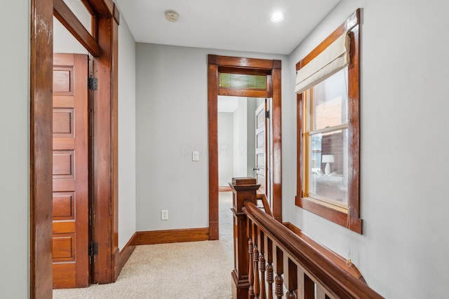 corridor featuring baseboards and carpet flooring