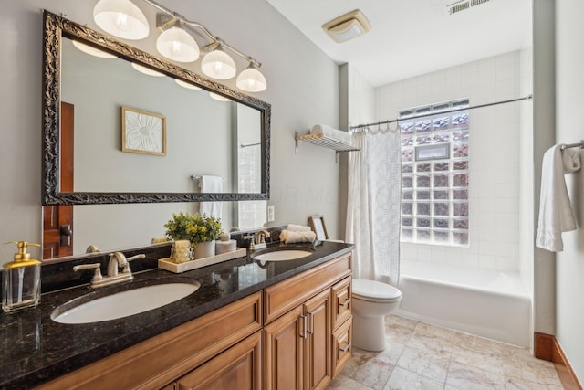 bathroom with double vanity, toilet, shower / bath combo with shower curtain, and a sink