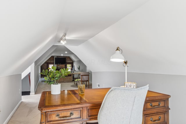 home office featuring baseboards, lofted ceiling, light carpet, and track lighting