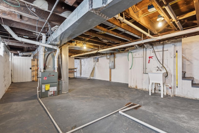 unfinished basement featuring electric panel, stairway, and heating unit