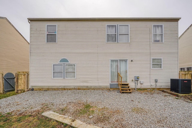 rear view of house featuring a gate, cooling unit, fence, and entry steps