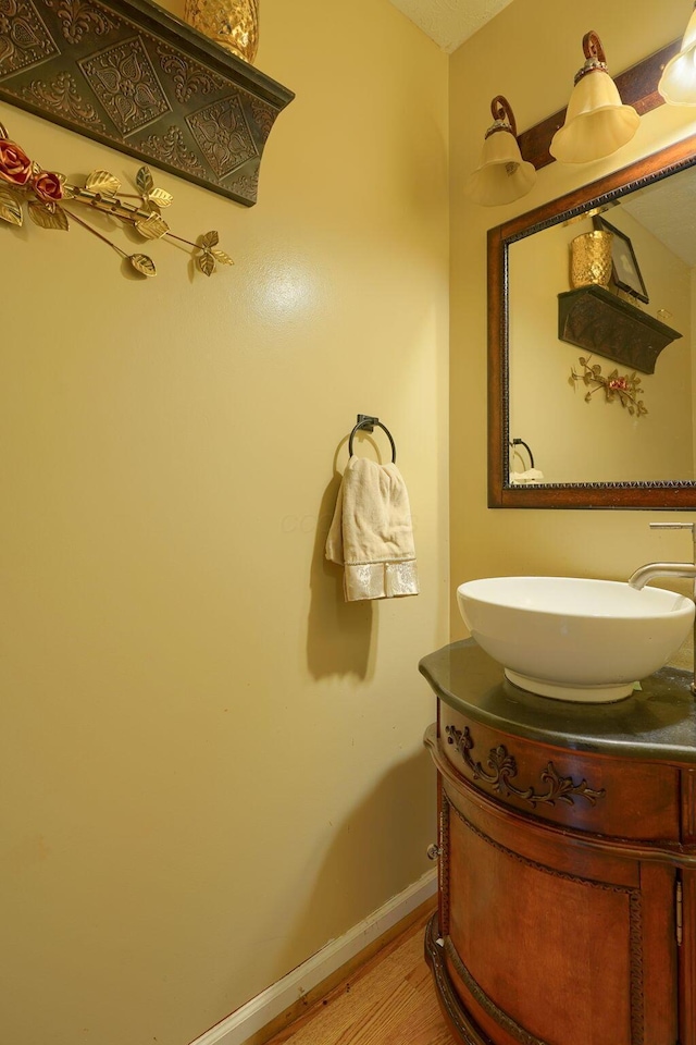 bathroom featuring vanity, baseboards, and wood finished floors