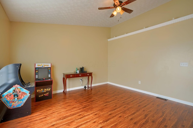 unfurnished room with visible vents, a textured ceiling, a ceiling fan, and wood finished floors