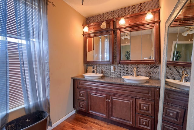 bathroom with decorative backsplash, wood finished floors, and a sink