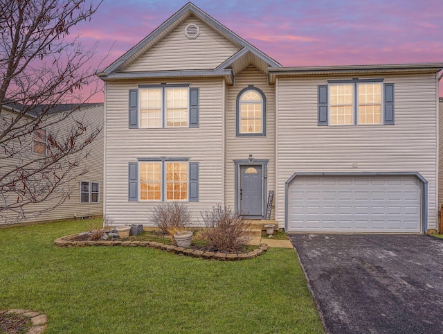 traditional-style home with aphalt driveway, a garage, and a front lawn