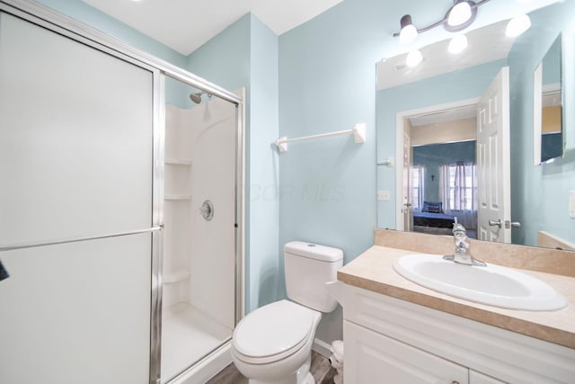 bathroom featuring a stall shower, toilet, ensuite bath, and vanity