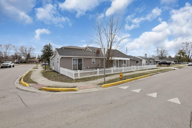 view of front of property featuring a fenced front yard, a residential view, and roof with shingles