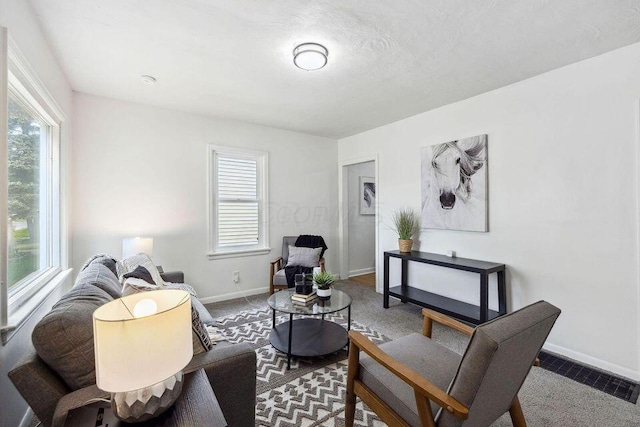 living room with a healthy amount of sunlight, visible vents, carpet floors, and baseboards