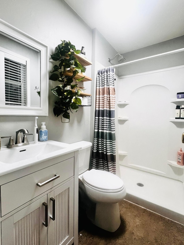 bathroom featuring vanity, toilet, and a stall shower