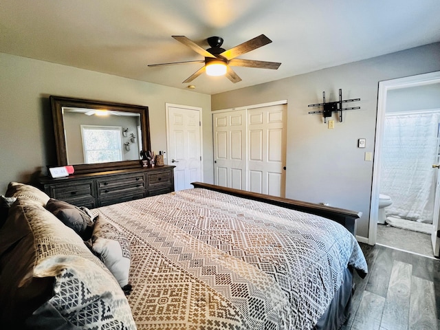 bedroom with dark wood-style floors, ceiling fan, ensuite bathroom, and a closet