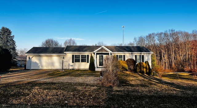 ranch-style home with a front lawn, an attached garage, and driveway