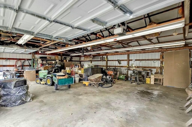 garage with a workshop area, a garage door opener, and metal wall