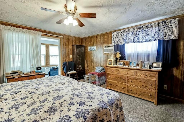 bedroom featuring wooden walls, a ceiling fan, a wall mounted air conditioner, a textured ceiling, and carpet flooring