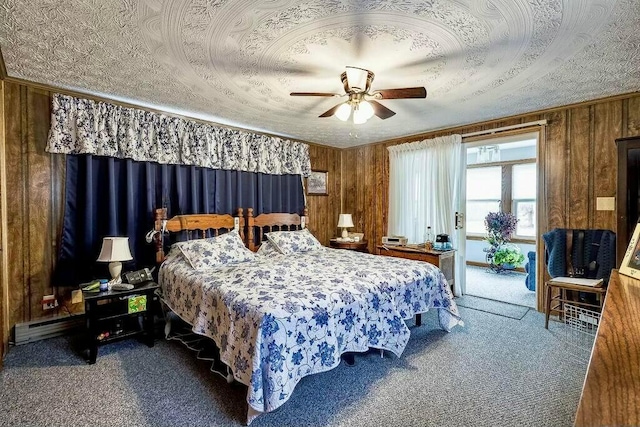 carpeted bedroom featuring a ceiling fan, wood walls, and a textured ceiling