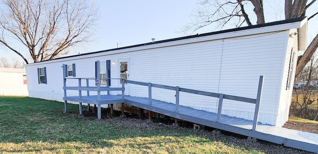 back of property featuring a lawn and a wooden deck