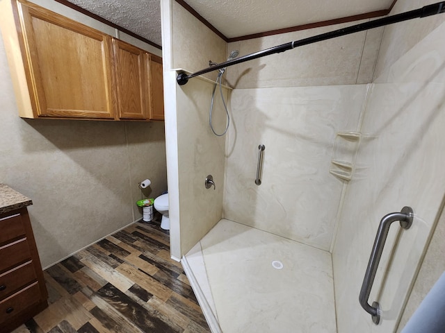 bathroom featuring vanity, toilet, wood finished floors, and a shower stall