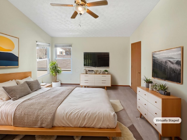 bedroom featuring ceiling fan, lofted ceiling, baseboards, and a textured ceiling