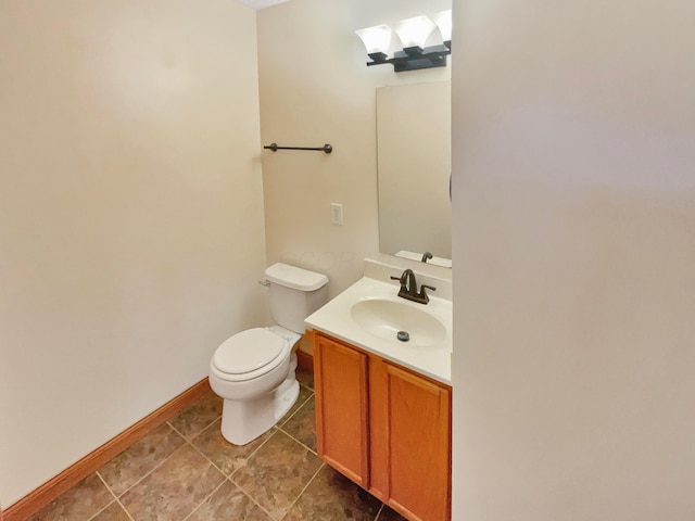 bathroom featuring baseboards, toilet, and vanity