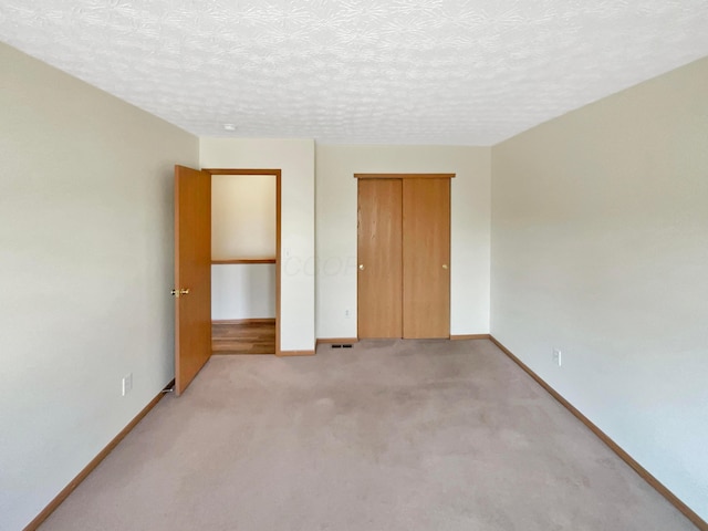 unfurnished bedroom with baseboards, a closet, and a textured ceiling