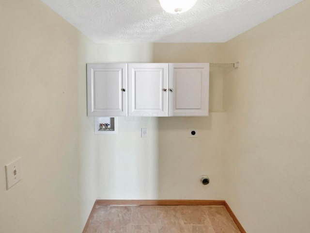 laundry room with baseboards, hookup for a washing machine, cabinet space, hookup for an electric dryer, and a textured ceiling