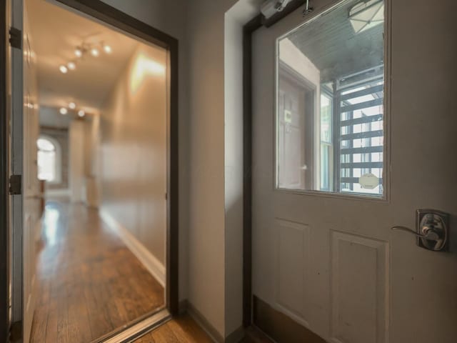 entryway with baseboards and wood finished floors