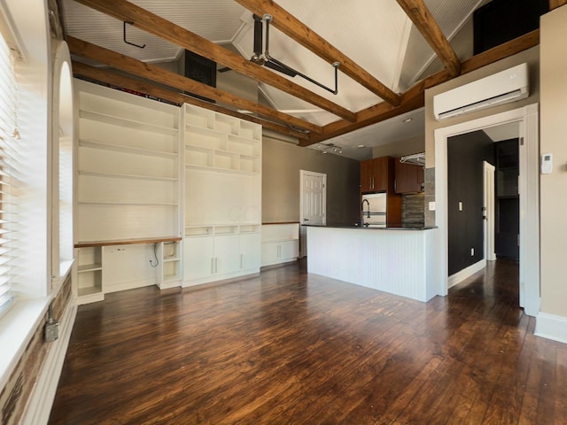 unfurnished living room featuring dark wood finished floors, beam ceiling, a wall mounted air conditioner, and high vaulted ceiling