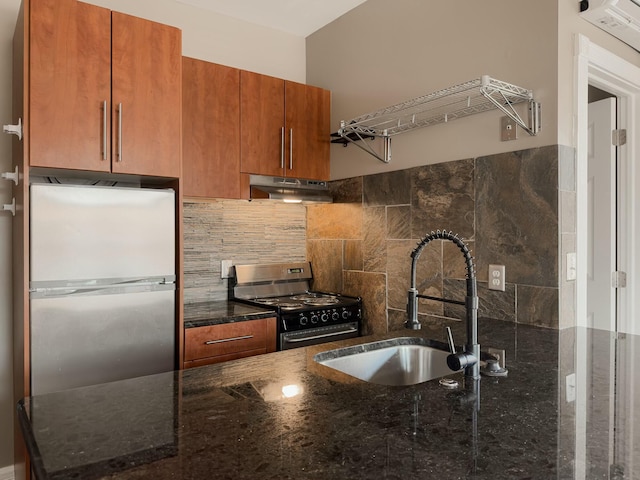 kitchen with under cabinet range hood, a sink, range with electric stovetop, freestanding refrigerator, and brown cabinetry