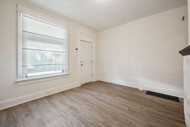 entrance foyer with wood finished floors, visible vents, and baseboards