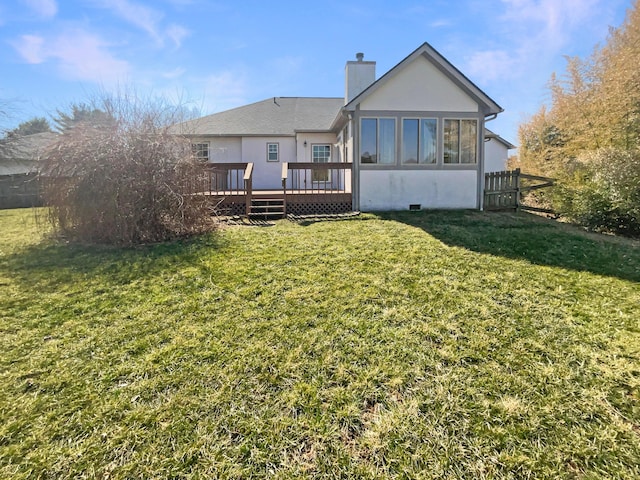 rear view of property featuring fence, a lawn, a chimney, a deck, and a sunroom