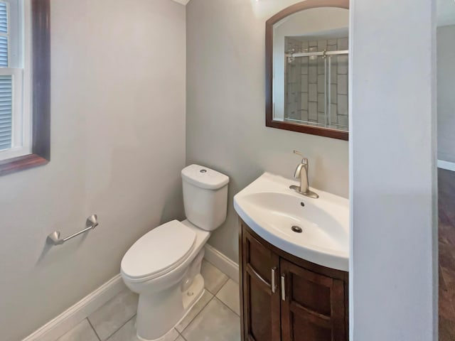 bathroom with vanity, baseboards, tile patterned flooring, a shower stall, and toilet