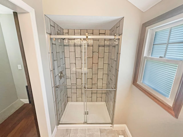 bathroom with baseboards and a stall shower