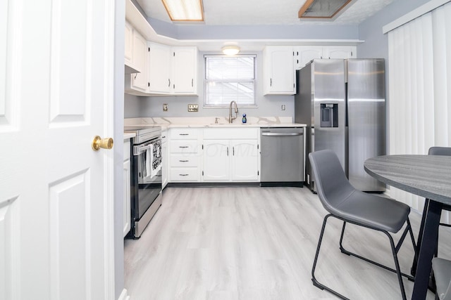 kitchen featuring a sink, white cabinets, and stainless steel appliances