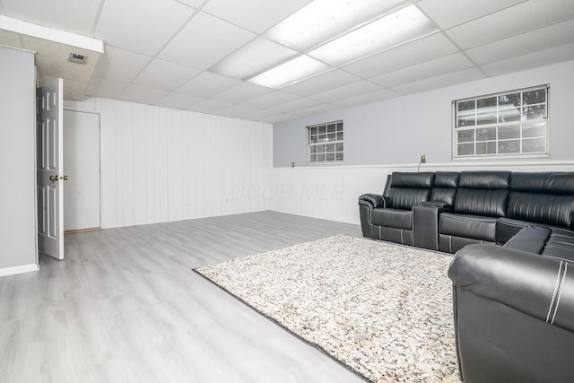 living area with wood finished floors and a paneled ceiling