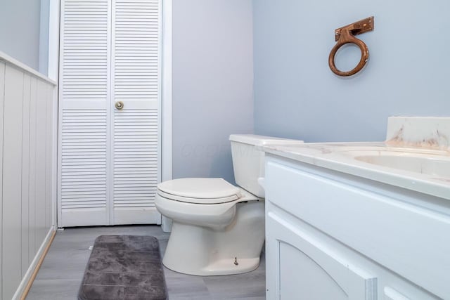 bathroom with toilet, wood finished floors, and vanity