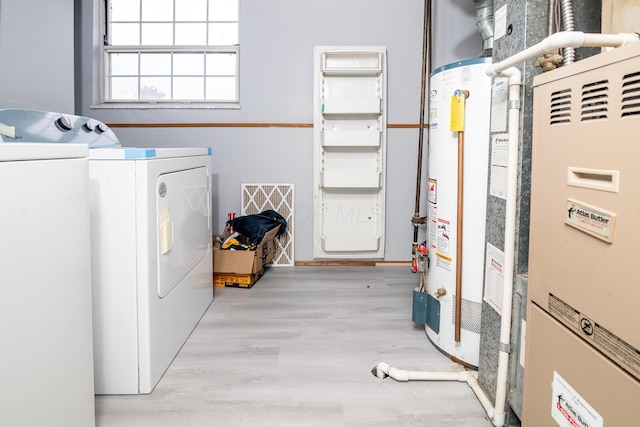 clothes washing area with light wood-type flooring, washer and clothes dryer, heating unit, gas water heater, and laundry area