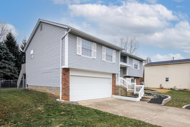 raised ranch with a front lawn, fence, concrete driveway, a garage, and brick siding