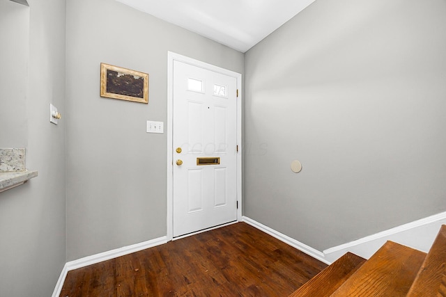 foyer entrance featuring dark wood finished floors and baseboards