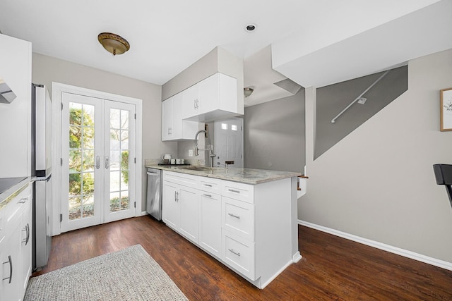 kitchen with dark wood-type flooring, a sink, light stone counters, appliances with stainless steel finishes, and baseboards