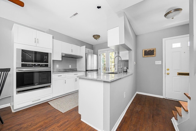 kitchen featuring visible vents, dark wood finished floors, a sink, stainless steel appliances, and white cabinets