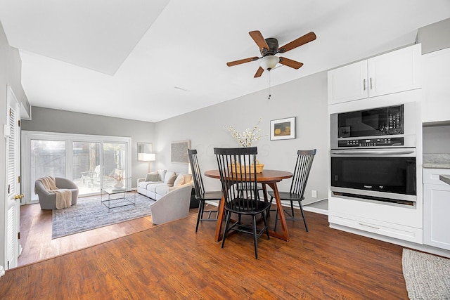 dining area featuring ceiling fan and dark wood-style floors