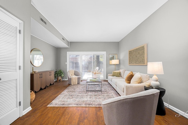 living room featuring visible vents, baseboards, and wood finished floors