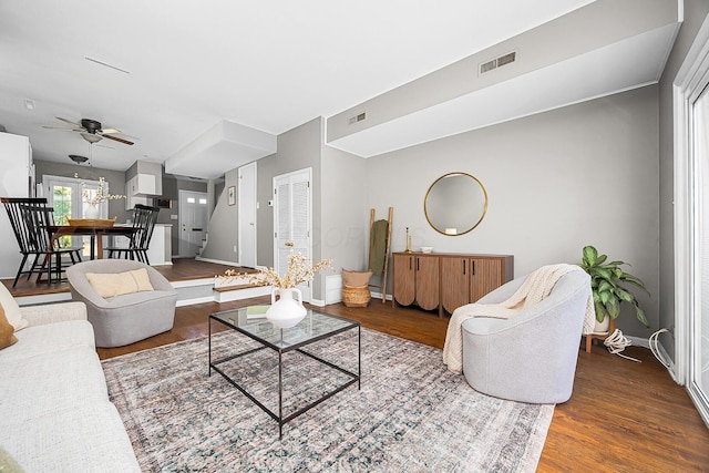 living area with visible vents, baseboards, and wood finished floors